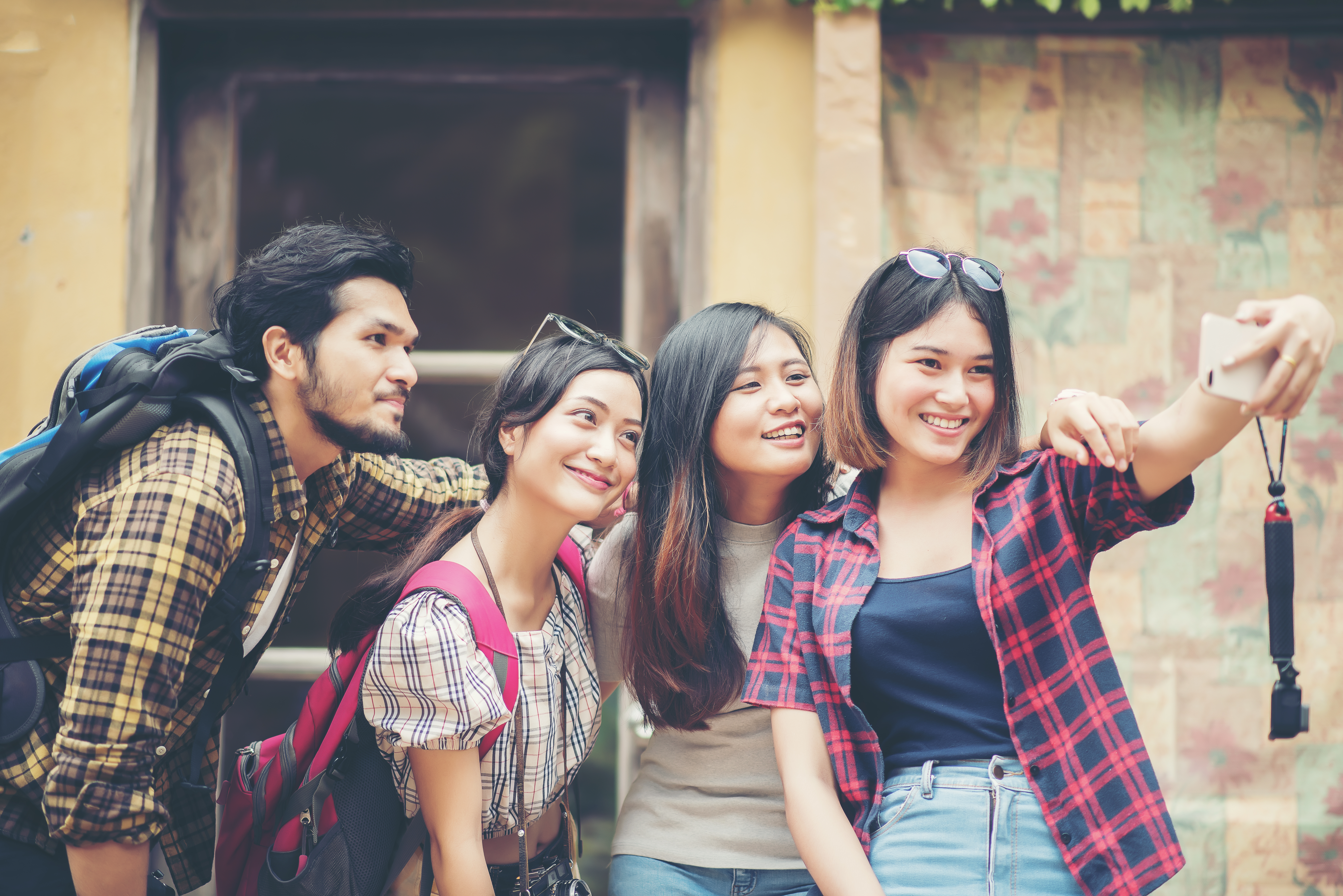 Planning study abroad from Japan — Group friends taking selfie urban street having good fun together.