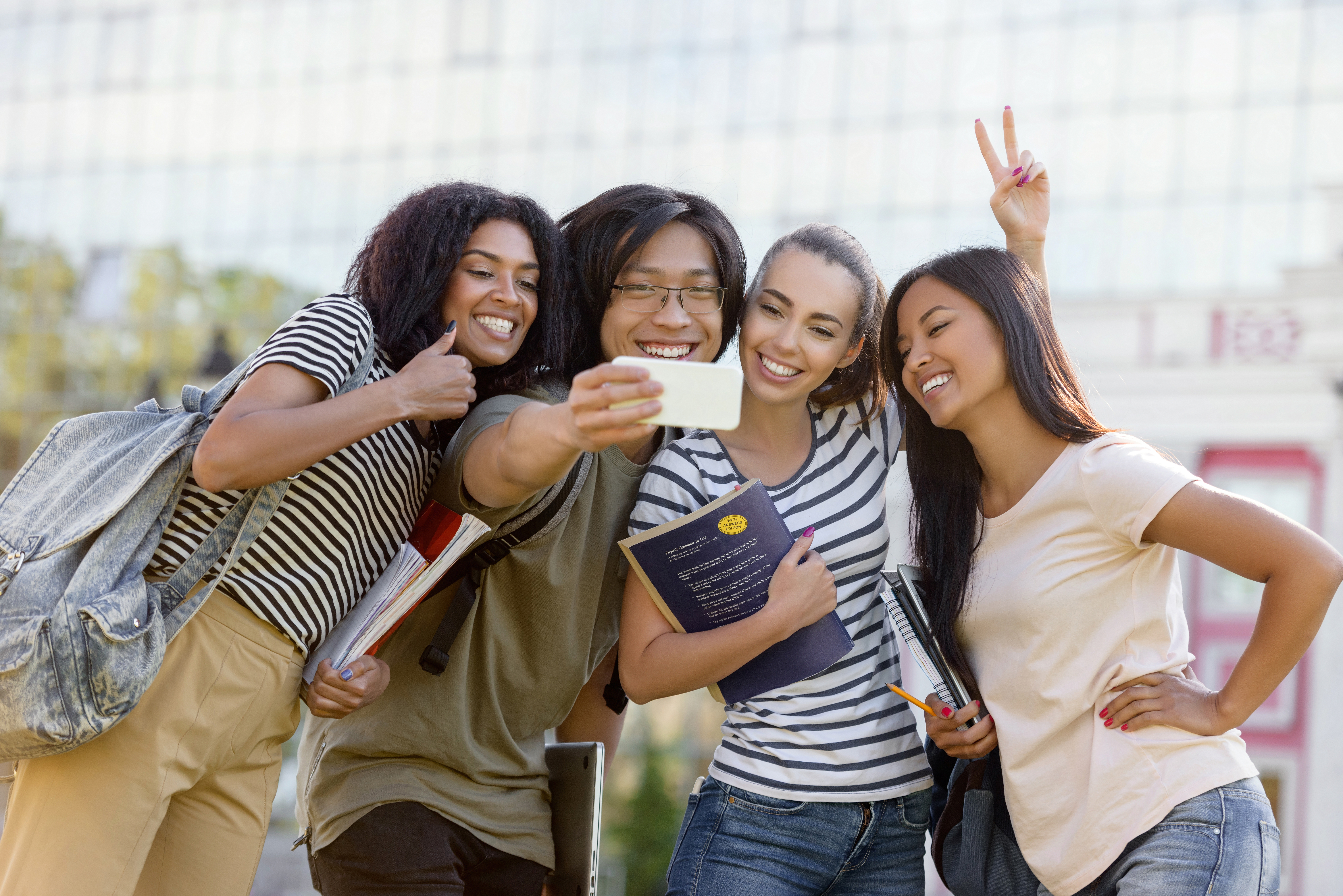 Steps for Singapore students — Happy students standing make selfie outdoors.